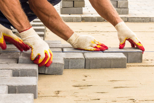 workers lay paving tiles, construction of brick pavement, close up architecture background stock photo