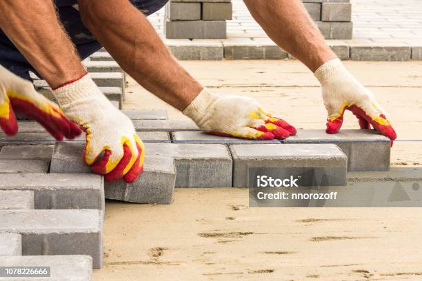 Workers Lay Paving Tiles Construction Of Brick Pavement Close Up Architecture Background Stock Photo - Download Image Now