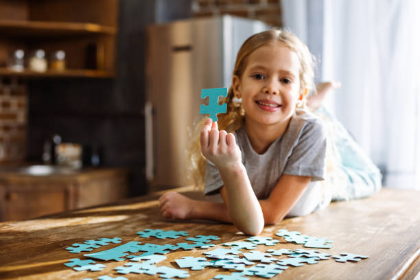 istock Cute smiling little girl playing with puzzles 1078231598