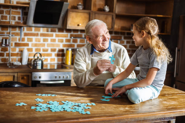 istock Cheerful aged man assembling pazzles with his granddaughter 1078231768