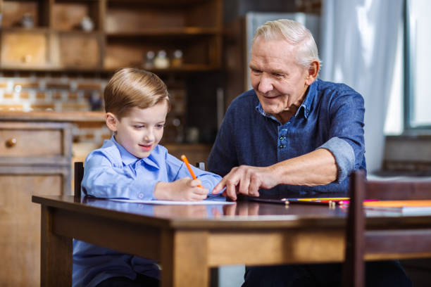 istock Cheerful elderly man drawing with his grandson 1078231846