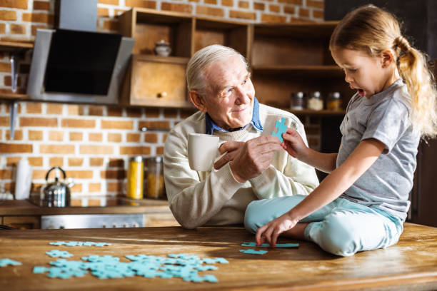istock Cute little girl assembling jigsaw puzzles with her grandfather 1078232072