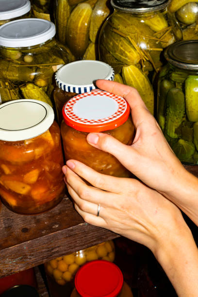 istock Woman puts jam jars in the basement, for storage for a long time. 1078232114