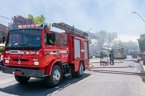 City: Pudahuel, Santiago de Chile\nCountry: Chile\nDate: 06th December 2018\nFirefighters and people fighting a fire inside a workshop in Pudahuel neighborhood at Santiago de Chile City in between smoke