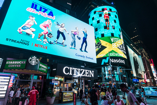 New York City, USA - July 30, 2018: Times Square at night with people around and large advertising screens in Manhattan in New York City, USA