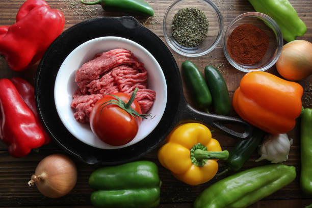 istock Raw ground beef inside skillet with peppers and other cooking ingredience around 1078243518