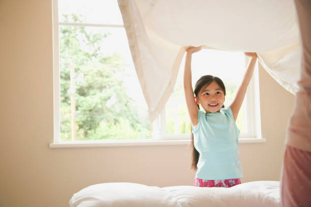 istock Asian daughter and mother making bed at home 1078250714