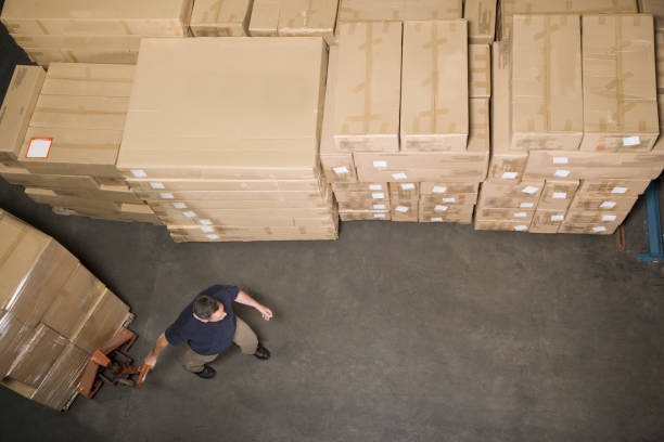 homem, puxando o patim de boneca com caixas no armazém de distribuição - warehouse box crate storage room - fotografias e filmes do acervo