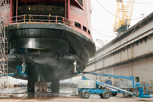 Workers repairing ferry boat ship in dry dock