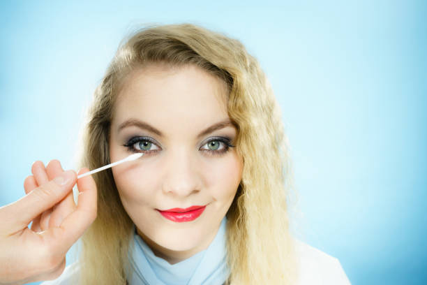 Professional artist fixing fashion model make up using ear buds cotton tipped swabs q tip