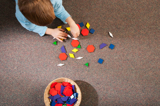 istock Child playing with toy shapes on carpet in grade school classroom 1078258664