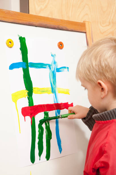 istock Young boy painting a picture in school classroom 1078258884