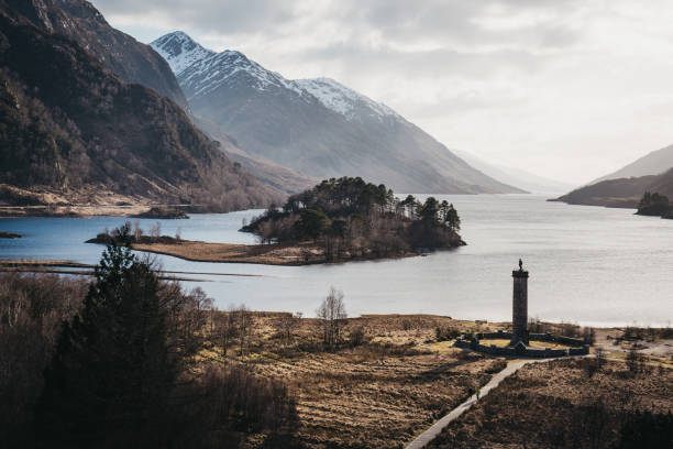 Glenfinnan Monument, Loch Shiel and Scottish landscape near Glenfinnan, Scotland. View of the Glenfinnan Monument, Loch Shiel and Scottish landscape near Glenfinnan, Inverness-shire, Scotland, on a cold spring sunny day. glenfinnan monument stock pictures, royalty-free photos & images