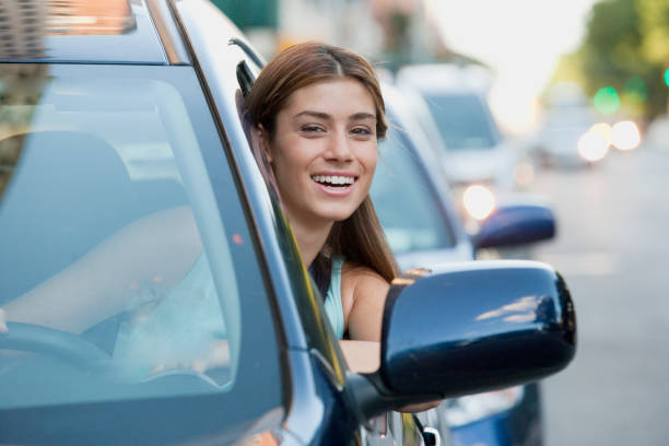 車から傾いて若い 10 代の女性の肖像画 - car insurance driving women ストックフォトと画像