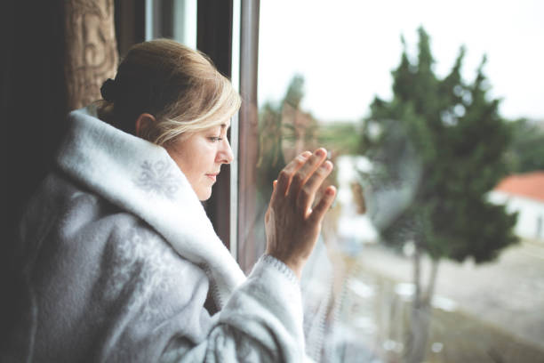 istock Alone woman day dreaming by the window 1078270248