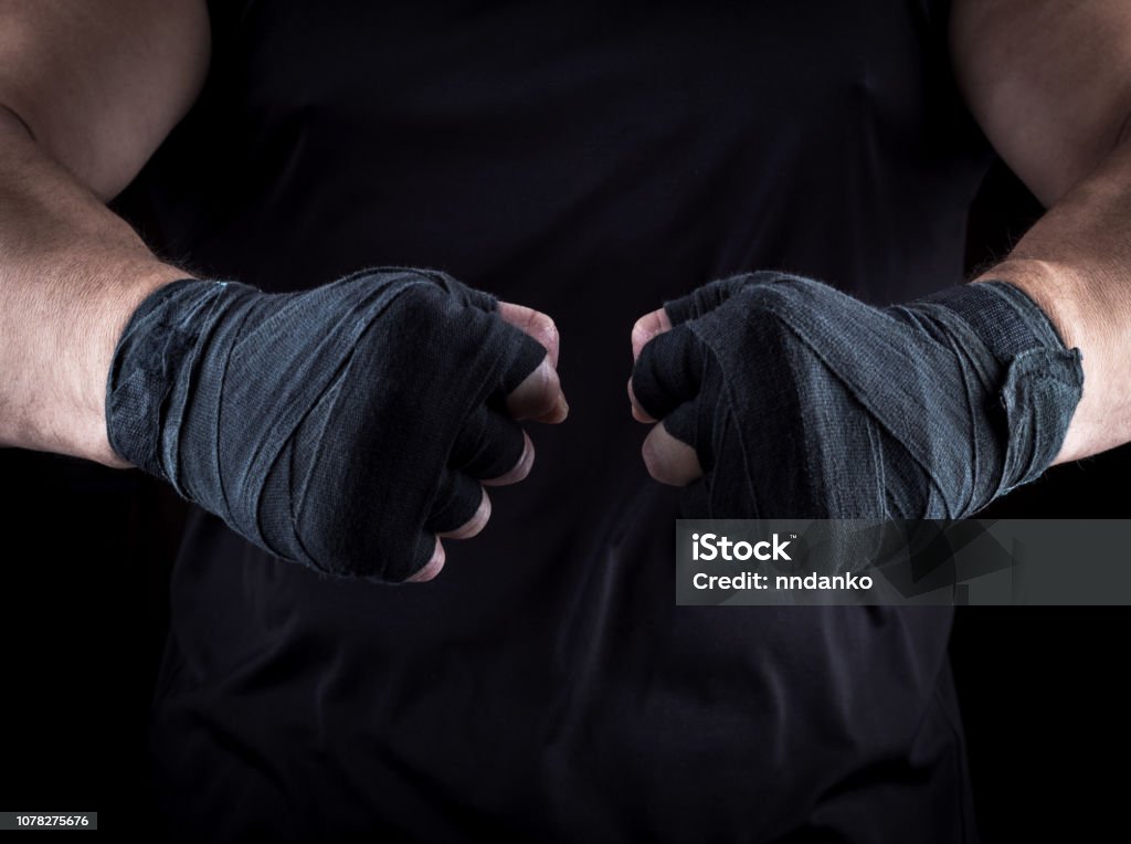 two men's hands wrapped in a black bandage two men's hands wrapped in a black bandage, close up Fist Stock Photo
