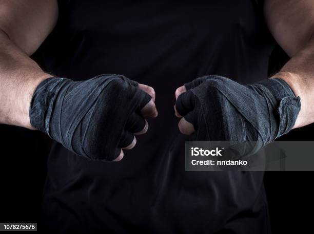 Two Mens Hands Wrapped In A Black Bandage Stock Photo - Download Image Now - Fist, Wrapping, Black Color