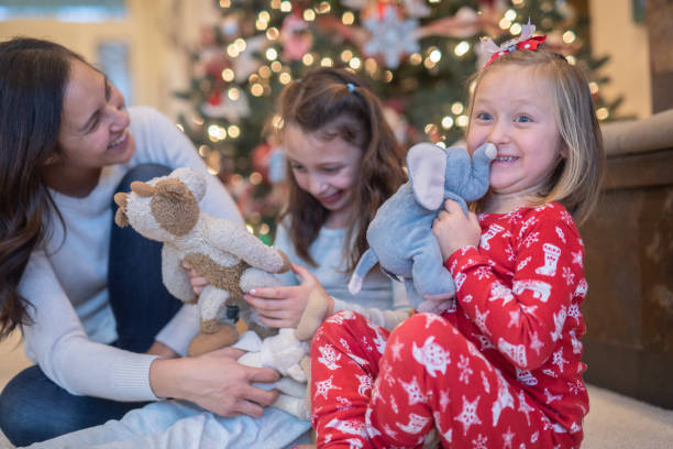 istock Mom laughs with her two daughters in front of the Christmas tree 1078276834