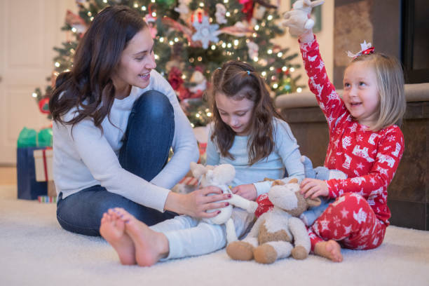 istock Mom laughs with her two daughters in front of the Christmas tree 1078276838
