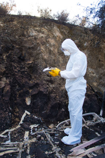 istock Man in Hazmat Suit Picking Through Wildfire Rubble 1078283618