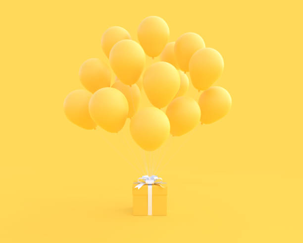желтая подарочная коробка и воздушный шар на желтом фоне - yellow balloon стоковые фото и изображения
