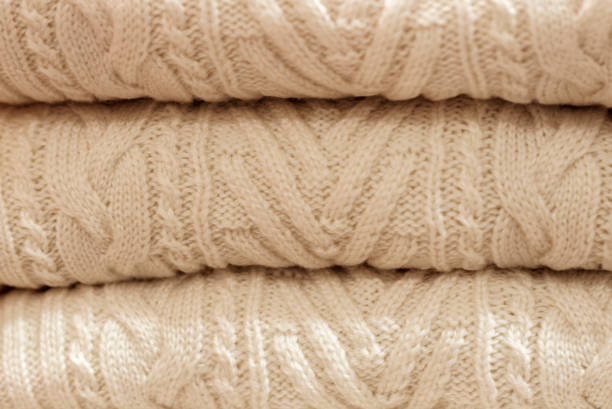 istock Stack of white woolen knitted sweaters close-up, texture, background 1078293164