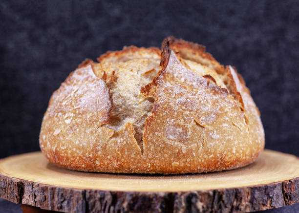 pan casero artesanal de broule de pan de masa madre con la corteza en una tabla de madera - enzo fotografías e imágenes de stock