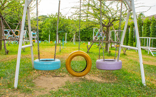 Swing chairs made from old tires  for children in park.