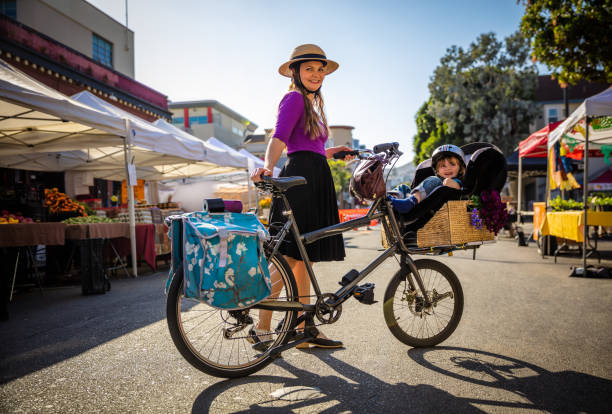 leende mamma och småbarn på bondens marknad med last cykel - parents children cargo bike bildbanksfoton och bilder