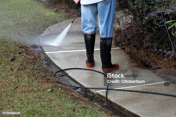 Worker Pressure Washing Conrete Sidewalk To Clean It Stock Photo - Download Image Now