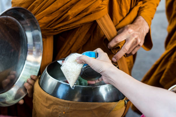 tazón de limosna de monje budista caminando en una calle para recibir ofertas de comida - laos luang phabang thailand religion fotografías e imágenes de stock