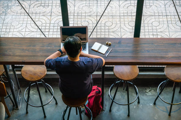 Young Asian freelancer working online on laptop stock photo