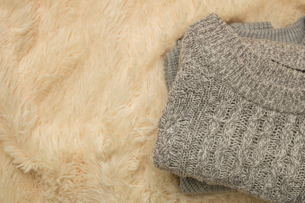 istock a gray knitted sweater is lying on a light fluffy blanket 1078351506