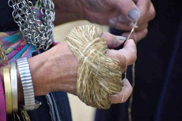 While walking, the women spin the hemp in order to make coils of threads ready to weave