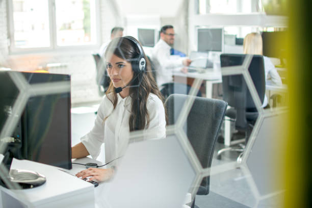 istock Through glass view of call center worker at office. 1078357240