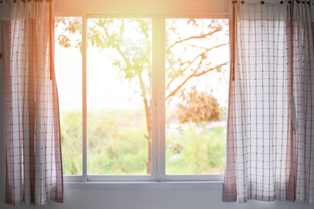 istock bedroom window in the morning room / sunlight through  open curtains window lights 1078357588