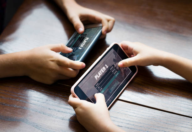 garoto jogando um jogo para celular contra sua irmã - video game child playing leisure games - fotografias e filmes do acervo