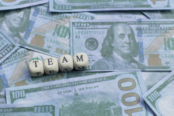 istock Team word on wood brick  background banknote. 1078384950