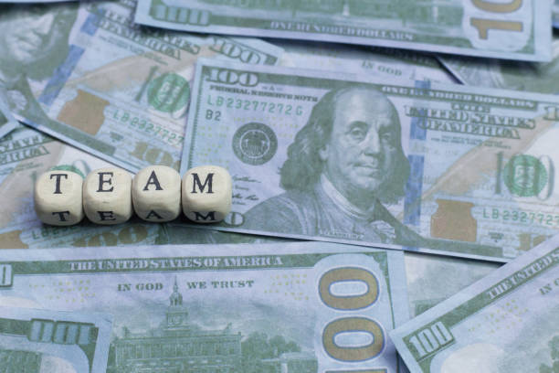 istock Team word on wood brick  background banknote. 1078384978