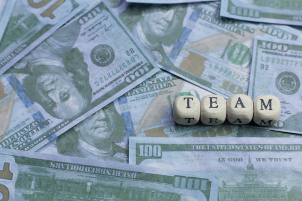 istock Team word on wood brick  background banknote. 1078384992