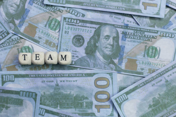 istock Team word on wood brick  background banknote. 1078385002