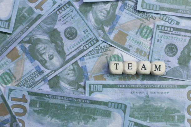 istock Team word on wood brick  background banknote. 1078385072