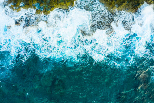Blue sea waves with a lot of sea foam. Beautiful blue waves with a lot of sea foam scene looked from above, close up.