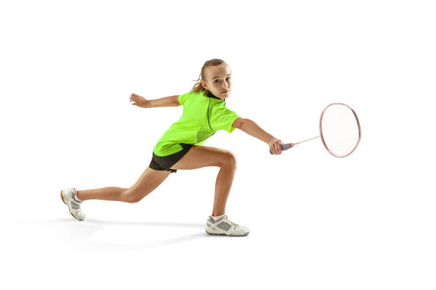 one caucasian young teenager girl woman playing Badminton player isolated on white background The one caucasian young teenager girl playing badminton at studio. The female teen player isolated on white background in motion badminton stock pictures, royalty-free photos & images