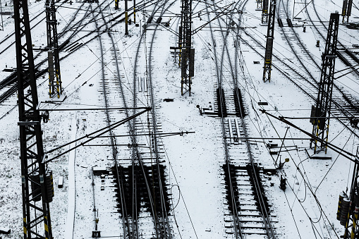 Color image depicting many railroad tracks diverging in the snow as they make their way towards their various travel destinations. Room for copy space.