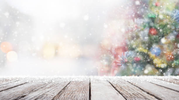 istock Empty wood table top on blur with bokeh Christmas tree background with snowfall - can be used for display or montage your products. 1078406842