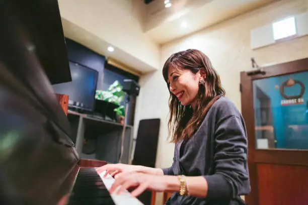 A young female pianist is playing the piano in a jazz bar