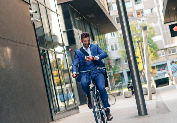 istock Smiling young businessman going to work with his bicycle. 1078408062