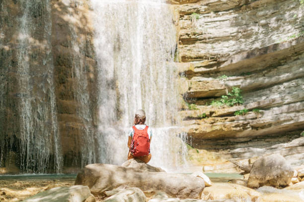istock Backpacker woman enjoying view of waterfall. 1078410088
