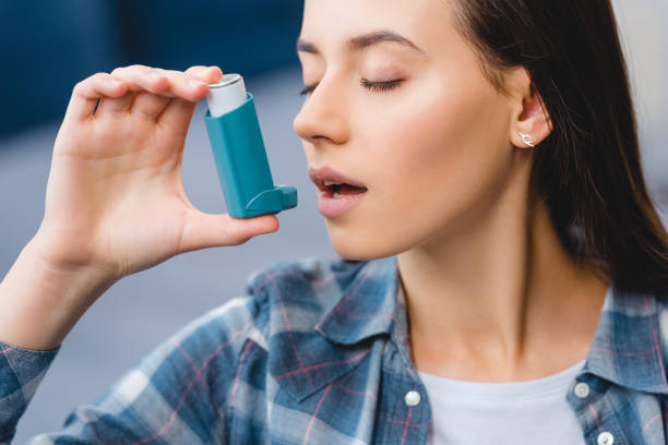 istock close-up view of young woman using inhaler while suffering from asthma 1078413970
